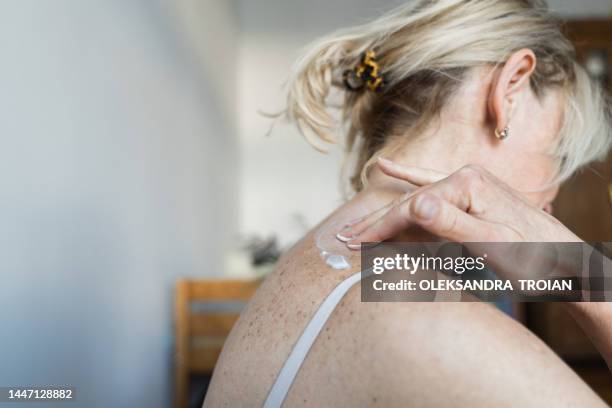 middle-aged woman using hormone gel on her skin, hormone replacement therapy - hormontherapie stock-fotos und bilder