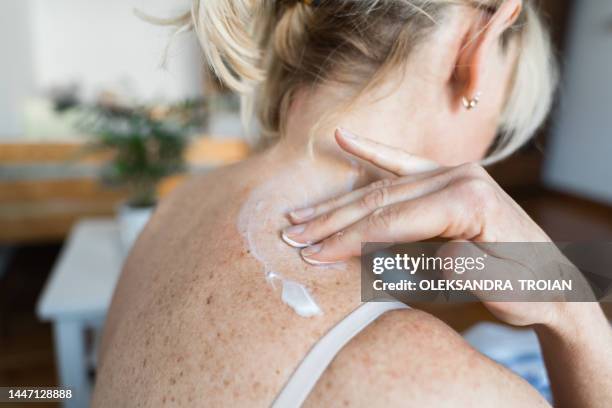 middle-aged woman using hormone gel on her skin, hormone replacement therapy - mettersi la crema foto e immagini stock