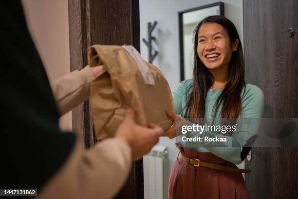 courier delivering fast food to the customer - food delivery stockfoto's en -beelden