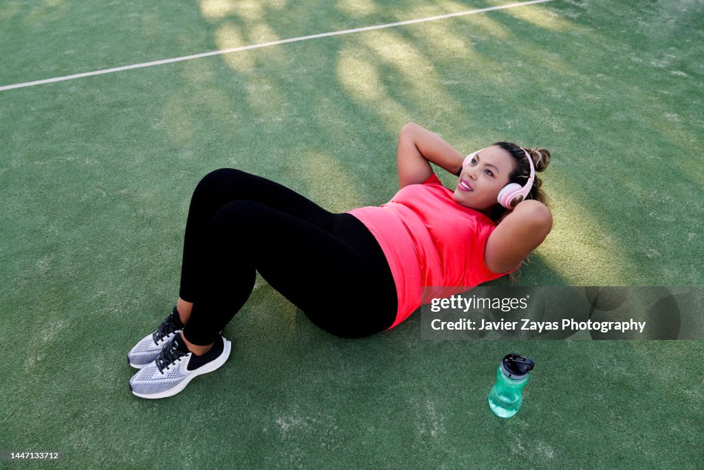 Plus Size Latin Woman Doing Sit-ups After Jogging