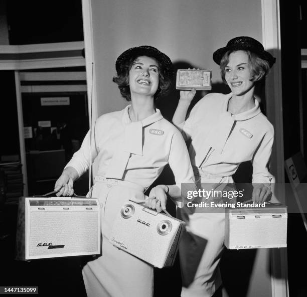 Models posing with portable radios in various sizes at a General Electric Company trade show in London on August 21st, 1961. The models are named as...