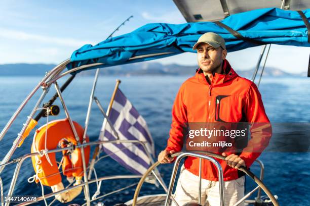 man sailing alone in autumn - orange coat stock pictures, royalty-free photos & images