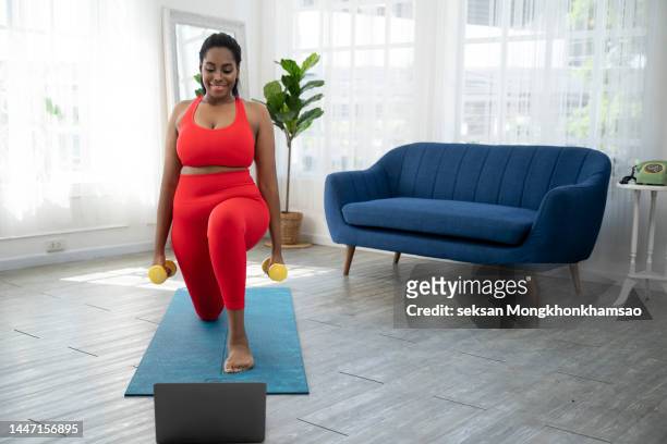 woman exercising at home following a fitness video online - chest torso stockfoto's en -beelden