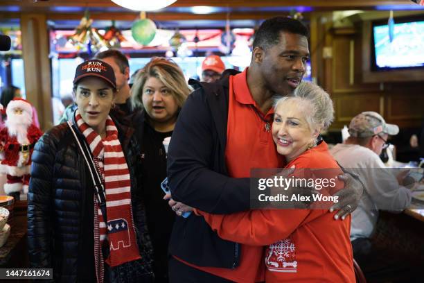 Georgia Republican Senate nominee Herschel Walker greets patrons as his wife Julie Blanchard looks on during a campaign stop at Marietta Diner on...