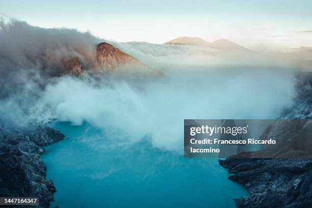 sulphur mining and blue lake in ijen crater volcano, java, indonesia - sulphur stock pictures, royalty-free photos & images