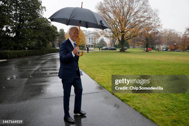 President Joe Biden uses an umbrella to keep out of the rain as he departs the White House on December 06, 2022 in Washington, DC. Biden is traveling...