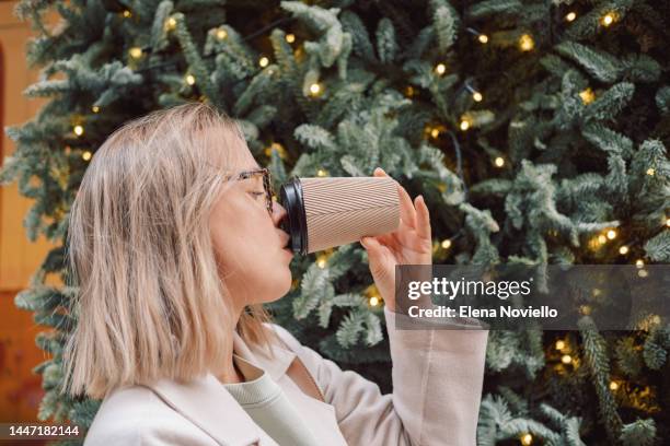 takeaway coffee young woman drinking hot coffee or tea from paper coffee cup outdoors - coffee cup disposable stock pictures, royalty-free photos & images