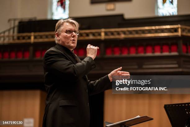 kirchenchorleiter während der konzertanten aufführung - dirigent stock-fotos und bilder