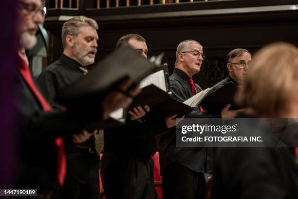 men singers in church choir during performance at concert - koor stockfoto's en -beelden