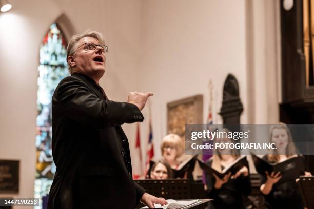 church choir conductor during concert performance - koor stockfoto's en -beelden