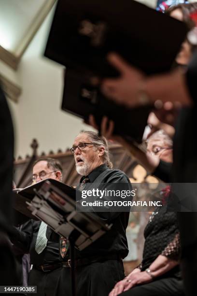 men singers in church choir during performance at concert - koor stockfoto's en -beelden