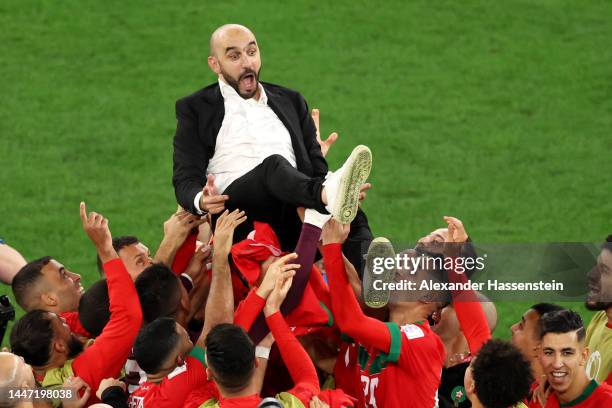 Walid Regragui, Head Coach of Morocco, celebrates with players after the team's victory in the penalty shoot out during the FIFA World Cup Qatar 2022...