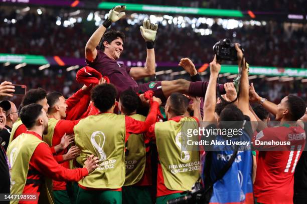 Yassine 'Bono' Bounou of Morocco is thrown in the air by his teammates after the penalty shootout during the FIFA World Cup Qatar 2022 Round of 16...