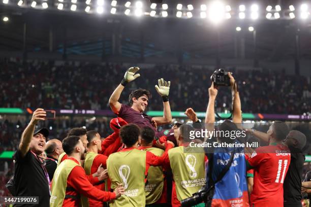 Yassine Bounou of Morocco is tossed into the air after the team's victory through the penalty shootout during the FIFA World Cup Qatar 2022 Round of...