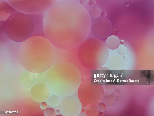 full frame of bubbles floating on a surface of moving pink liquid. - protozoo fotografías e imágenes de stock