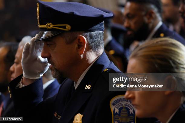 Capitol Police and D.C. Metropolitan Police officers hold their hands up in salute during the Congressional Gold Medal Ceremony in the Rotunda of the...