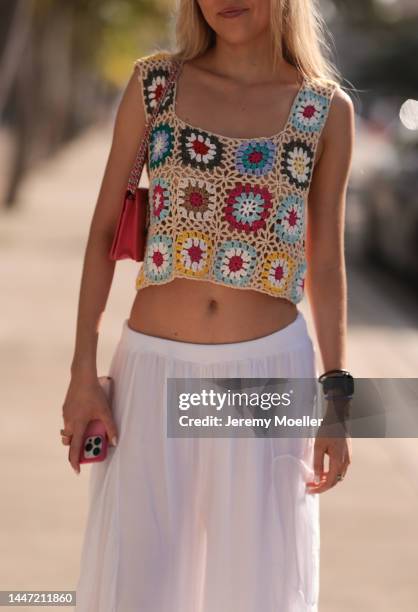 Guest seen wearing a flower knit shirt and white wide pants on December 03, 2022 in Miami, Florida.
