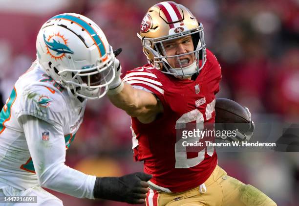 Christian McCaffrey of the San Francisco 49ers fights off the tackle of Kader Kohou of the Miami Dolphins during the fourth quarter of an NFL...