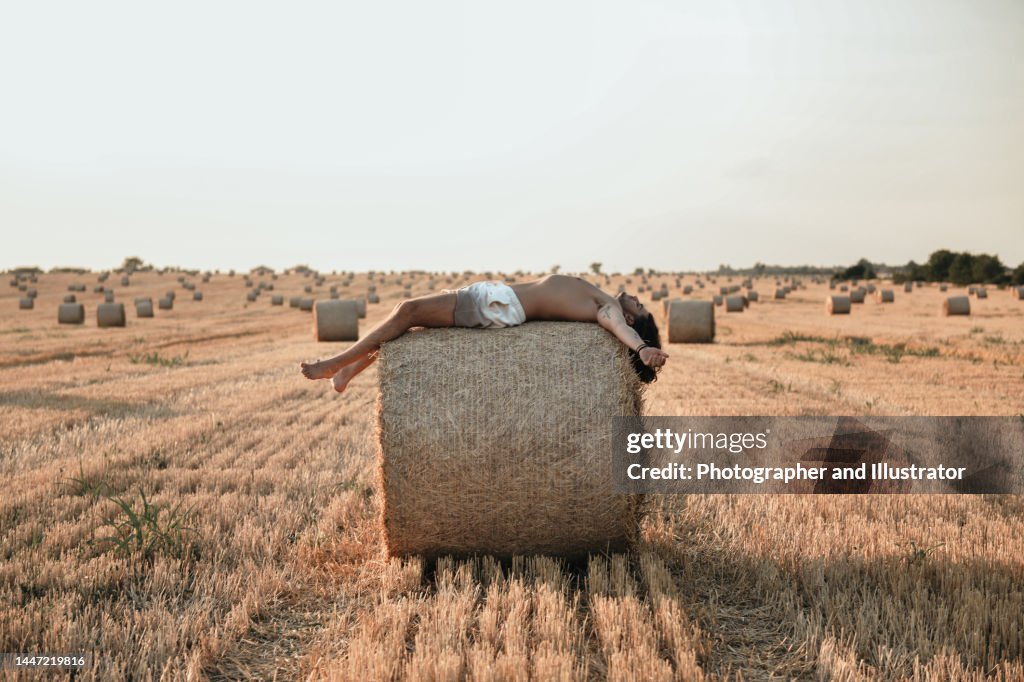 Young man lies on a haystack