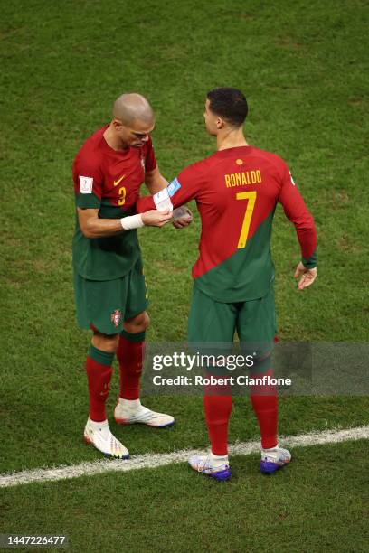 Cristiano Ronaldo of Portugal lets the captain's armband worn by Pepe after being brought in during the FIFA World Cup Qatar 2022 Round of 16 match...