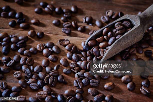 background of coffee beans on rustic wooden table - decaffeinated stock pictures, royalty-free photos & images