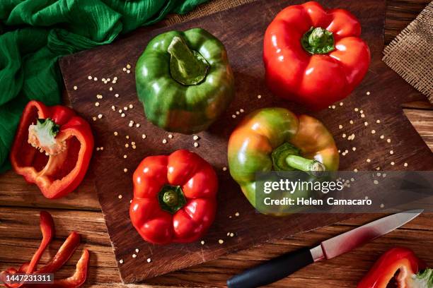 fresh red and green sweet pepper on a wooden rustic board - bell pepper stock pictures, royalty-free photos & images