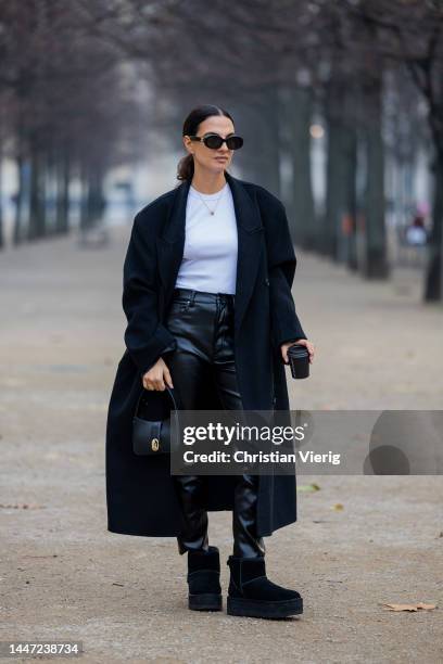 Anna Winter wears black leather pants, white top, bag Anine Bing, Celine sunglasses, Ugg boots on December 05, 2022 in Berlin, Germany.