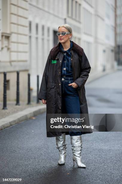 Tina Haase wears Ganni x Babour dark green wax jacket, Blanche dark blue denim jacket & jeans, Scarosso x Brian Atwood silver metallic boots on...