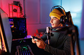 Teenage Boy Playing Multiplayer Games on Desktop Pc in his Dark Room