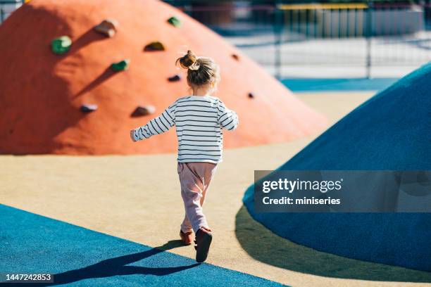 unrecognizable little girl running on the playground - speeltuin stockfoto's en -beelden