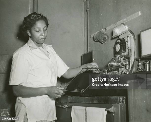 African American Private Hannah Wills developing an x-ray film in the x-ray laboratory at Post Hospital, Camp Breckinridge, 1943. Creator: Unknown.