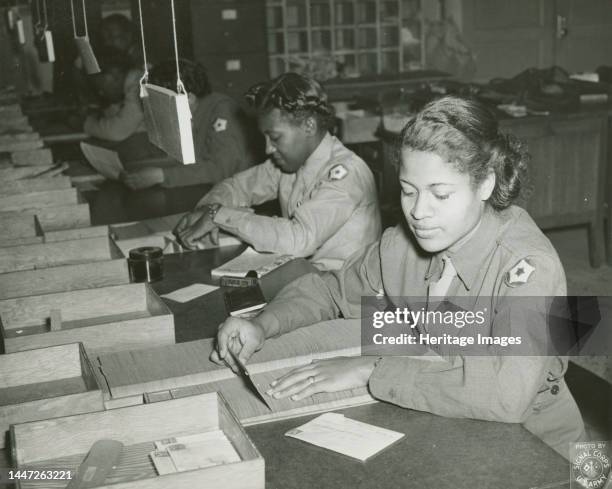 Members of the Women's Army Corps identifying incorrectly addressed mail for soldiers, Post Locator Department, Camp Breckinridge, 1943. Creator:...