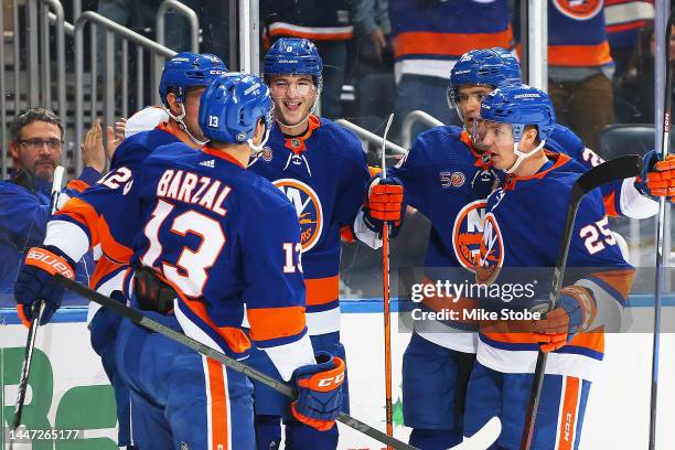 Noah Dobson of the New York Islanders celebrates his first period goal with Mathew Barzal and Sebastian Aho against the St. Louis Blues at UBS Arena...