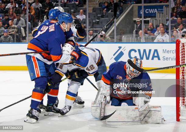 Noah Dobson of the New York Islanders holds on to William Bitten of the St. Louis Blues during the first period at the UBS Arena on December 06, 2022...