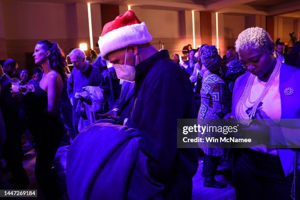 Audience members looks at election return numbers at an election night watch party for Sen. Raphael Warnock at the Marriott Marquis on December 6,...