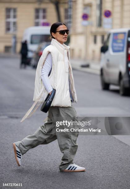 Anna Winter wears white Ganni vest, Weekday turtleneck, Oakly sunglasses, Adidas Sneaker, Coperni bag, grey pants on December 05, 2022 in Berlin,...