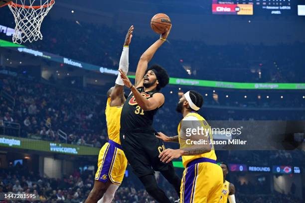 Jarrett Allen of the Cleveland Cavaliers dunks over LeBron James and Anthony Davis of the Los Angeles Lakers during the first quarter at Rocket...