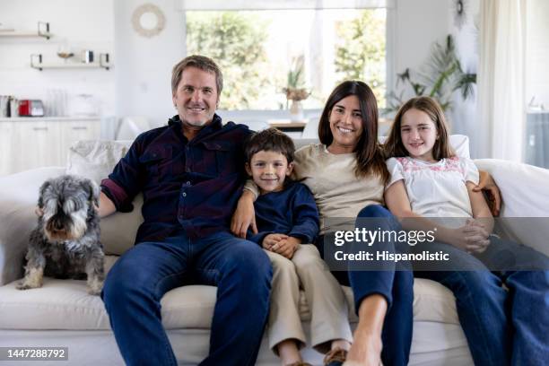 happy family smiling at home with their dog - girl on couch with dog stock pictures, royalty-free photos & images