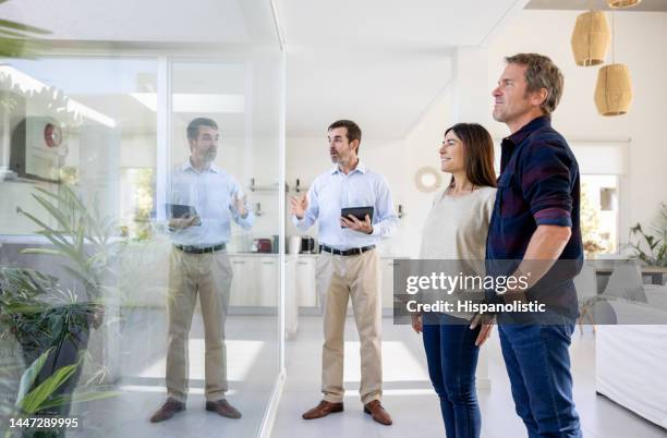 real estate agent showing a beautiful house to a couple - showsview stock pictures, royalty-free photos & images