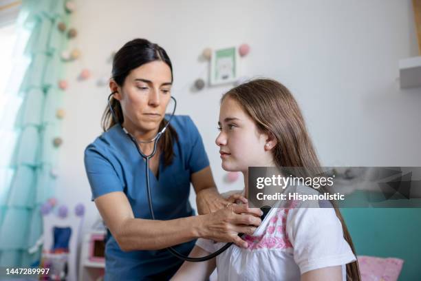 doctor on a house call listening to the heartbeat of a girl - kids call 911 stock pictures, royalty-free photos & images