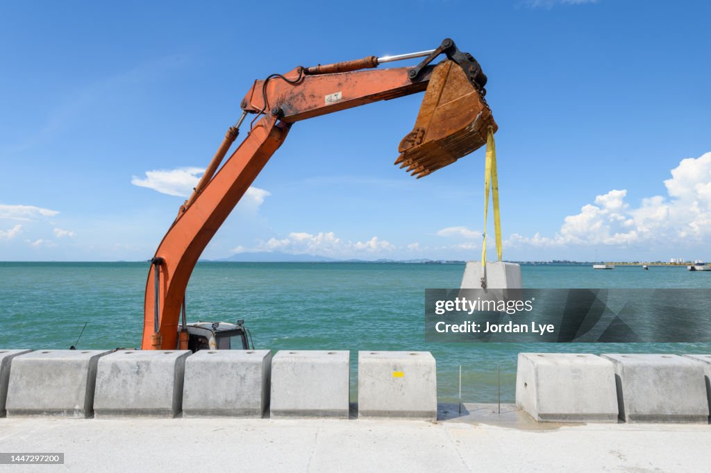 Building Harbour wall with Construction excavator