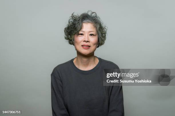 studio portrait on gray background - grey hair cool woman stock-fotos und bilder