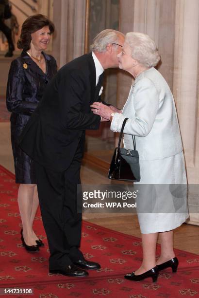 Queen Slivia of Sweden and King Carl XVI Gustaf of Sweden are greeted by Queen Elizabeth II at a lunch For Sovereign Monarchs in honour of Queen...