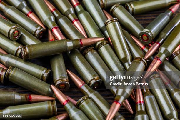 kalashnikov assault rifle cartridges on wooden background close-up - russische kultur stock-fotos und bilder