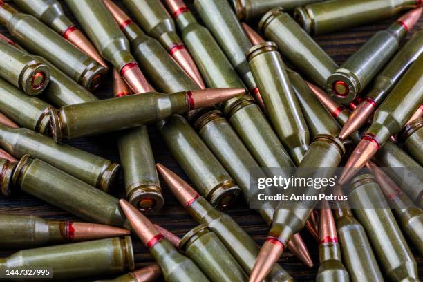 kalashnikov assault rifle cartridges on wooden background close-up - テロリズム ストックフォトと画像