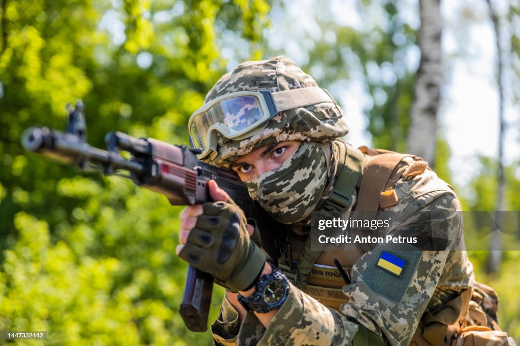 Ukrainian soldier with Kalashnikov assault rifle in the forest