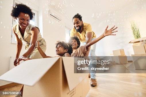 Carefree black family having fun after moving into a new home.