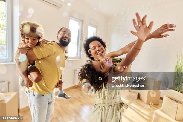 cheerful black family having fun after moving into a new apartment. - carefree moment stock pictures, royalty-free photos & images