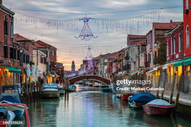 canal at sunset with christmas lights, murano, venice - murano stock pictures, royalty-free photos & images