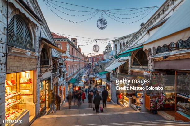 venice with christmas lights and people shopping - italy winter stock pictures, royalty-free photos & images